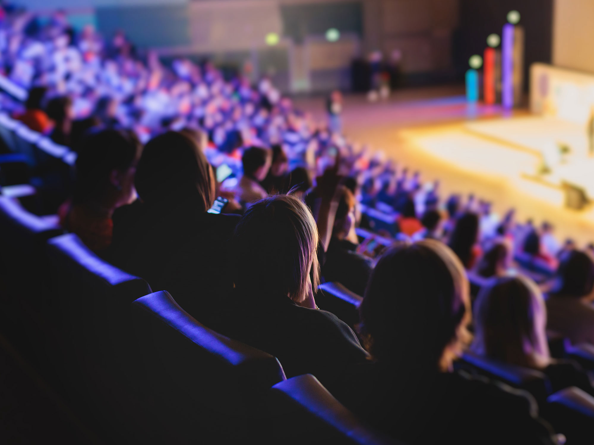 About 1 Crowded hall with engaged audience members.
